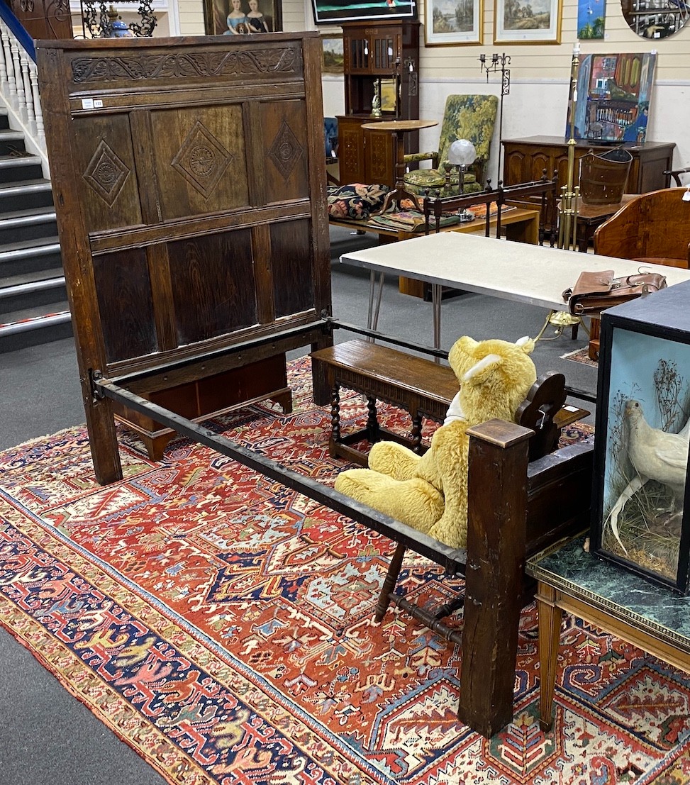 A 17th century style carved oak single head and foot bedstead, length 210cm, width 127cm, height 172cm